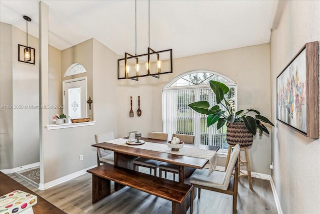 3661 Misty, Woods, FL 32571 - dining room featuring baseboards, wood finished floors, a chandelier, and high vaulted ceiling