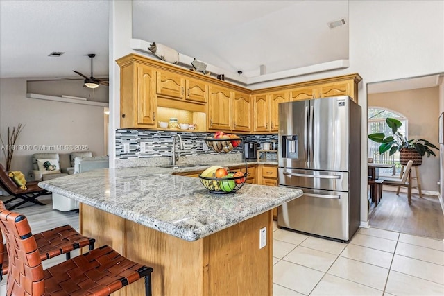 3661 Misty, Woods, FL 32571 - kitchen with stainless steel refrigerator with ice dispenser, a sink, decorative backsplash, a peninsula, and light stone counters