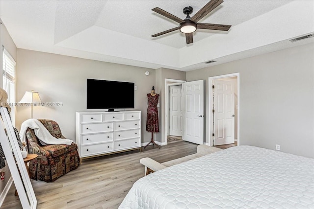 3661 Misty, Woods, FL 32571 - bedroom featuring a raised ceiling, light wood-style flooring, a ceiling fan, and a textured ceiling