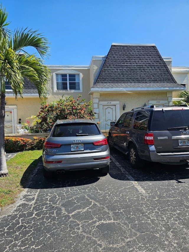 2418 NE 10th St Unit 127, Hallandale Beach, FL 33009 - view of front of home with stucco siding, uncovered parking, and a shingled roof