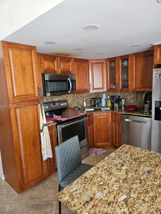 2418 NE 10th St Unit 127, Hallandale Beach, FL 33009 - kitchen with stainless steel appliances, tasteful backsplash, and light stone counters