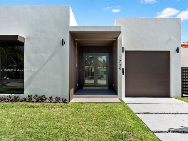 1735 SW 24th Ter, Miami, FL 33145 - entrance to property with stucco siding, an attached garage, a yard, french doors, and driveway