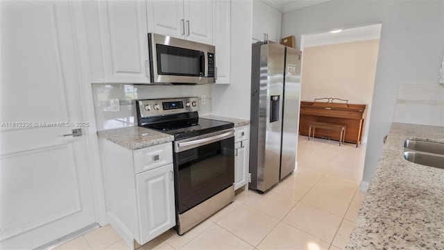 1621 NW 87th Ln, Plantation, FL 33322 - kitchen with stainless steel appliances, crown molding, white cabinetry, light tile patterned floors, and light stone counters