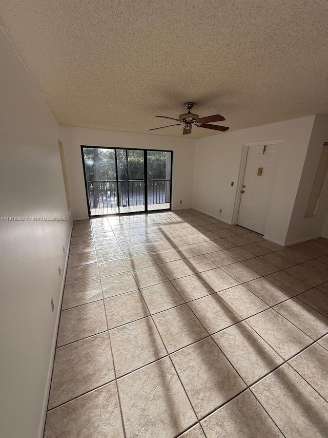 721 Sunny Pine Way Unit D2, Green Acres, FL 33415 - empty room with a textured ceiling, a ceiling fan, tile patterned floors, and baseboards
