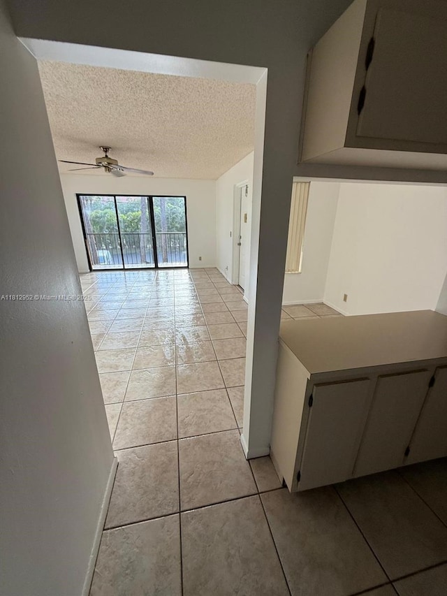 721 Sunny Pine Way Unit D2, Green Acres, FL 33415 - corridor featuring light tile patterned flooring, a textured ceiling, and baseboards