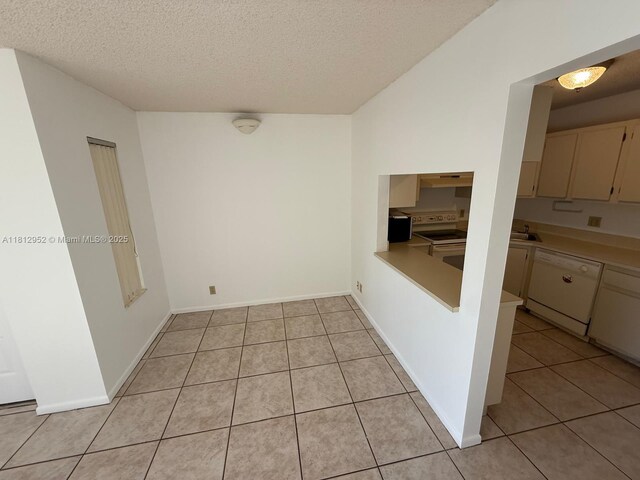 721 Sunny Pine Way Unit D2, Green Acres, FL 33415 - unfurnished dining area with light tile patterned floors, a textured ceiling, a sink, and baseboards