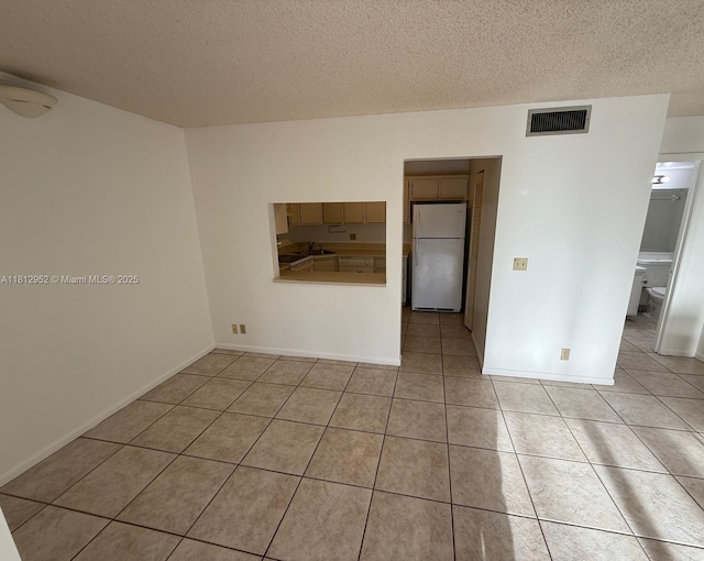 721 Sunny Pine Way Unit D2, Green Acres, FL 33415 - spare room with light tile patterned flooring, a textured ceiling, a sink, and baseboards