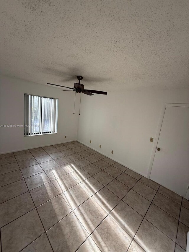 721 Sunny Pine Way Unit D2, Green Acres, FL 33415 - unfurnished room featuring a textured ceiling, a ceiling fan, and tile patterned floors