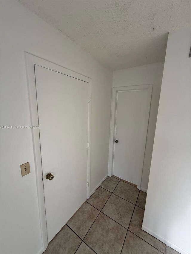 721 Sunny Pine Way Unit D2, Green Acres, FL 33415 - corridor with a textured ceiling and light tile patterned floors