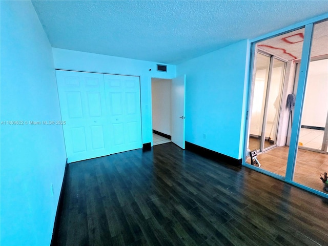17890 W Dixie Hwy Unit 302, Miami, FL 33160 - unfurnished bedroom featuring wood finished floors, a textured ceiling, a closet, and baseboards