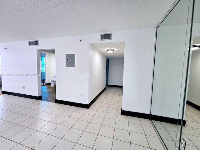 17890 W Dixie Hwy Unit 302, Miami, FL 33160 - unfurnished room featuring electric panel, a textured ceiling, light tile patterned floors, and baseboards