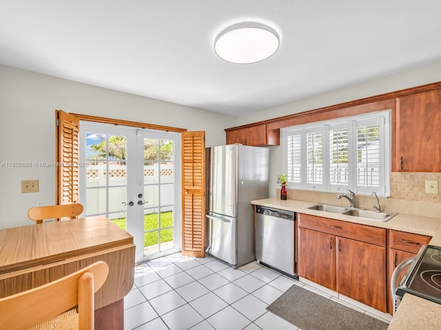 6566 NW 197th Ln, Hialeah, FL 33015 - kitchen featuring appliances with stainless steel finishes, a sink, french doors, light countertops, and healthy amount of natural light