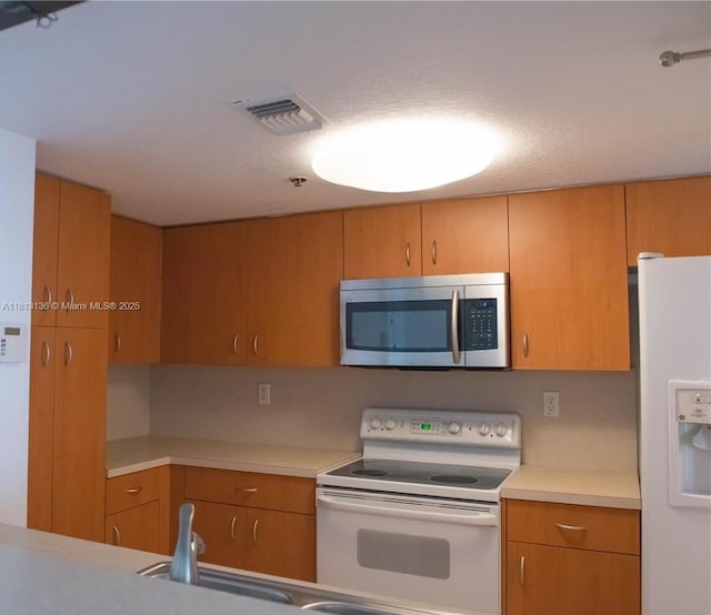 1650 Coral Way Unit 512, Miami, FL 33145 - kitchen with white appliances, light countertops, and brown cabinets