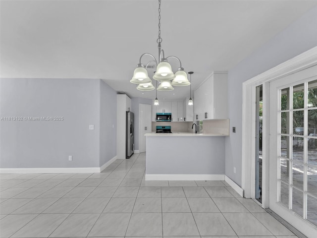 6525 SW 18th St, Miramar, FL 33023 - kitchen with appliances with stainless steel finishes, a chandelier, a sink, white cabinetry, and light countertops