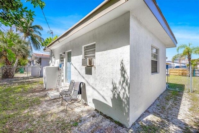 121 SW 5th Ct, Dania Beach, FL 33004 - view of side of property featuring stucco siding, a gate, and cooling unit