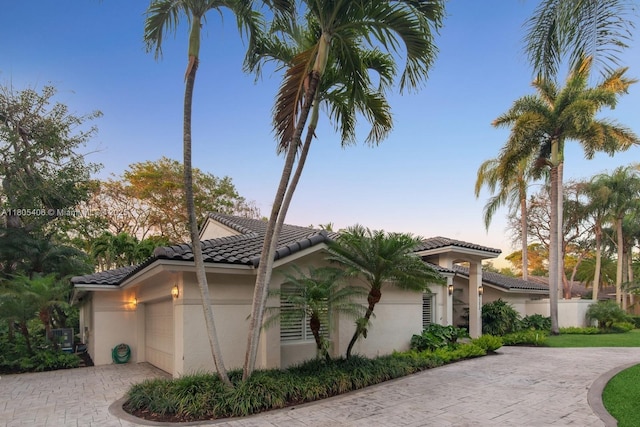 7395 SW 166th St, Palmetto Bay, FL 33157 - view of side of home featuring decorative driveway, stucco siding, a garage, and a tiled roof