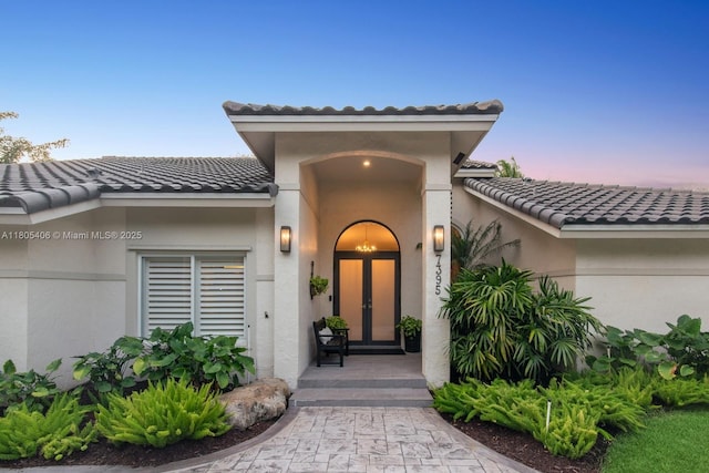 7395 SW 166th St, Palmetto Bay, FL 33157 - exterior entry at dusk featuring a tile roof and stucco siding