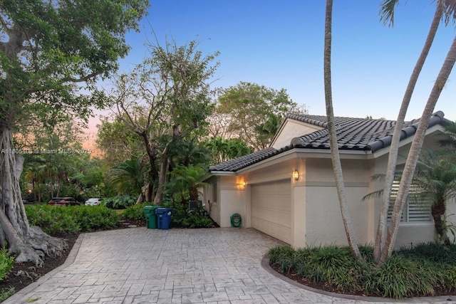 7395 SW 166th St, Palmetto Bay, FL 33157 - view of home's exterior featuring stucco siding, an attached garage, a tile roof, and decorative driveway