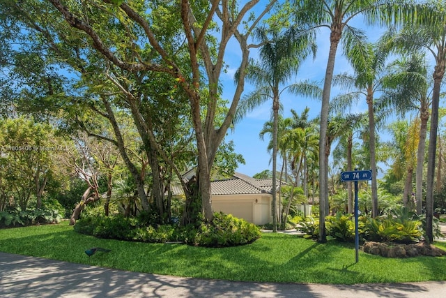 7395 SW 166th St, Palmetto Bay, FL 33157 - view of home's exterior with an attached garage, a lawn, a tiled roof, and stucco siding