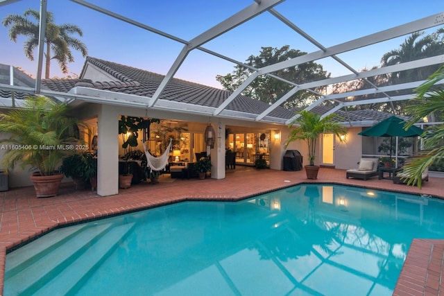7395 SW 166th St, Palmetto Bay, FL 33157 - pool at dusk featuring an outdoor pool, a patio, an outdoor living space, and area for grilling