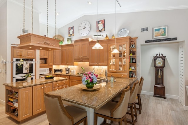 7395 SW 166th St, Palmetto Bay, FL 33157 - kitchen with open shelves, a center island with sink, white microwave, a sink, and stainless steel double oven