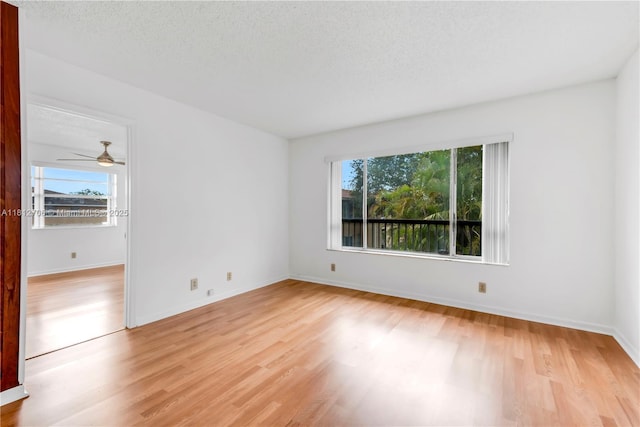 9906 Twin Lakes Dr Unit 7-I, Coral Springs, FL 33071 - spare room featuring healthy amount of natural light, light wood-type flooring, baseboards, and a textured ceiling