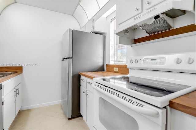 9906 Twin Lakes Dr Unit 7-I, Coral Springs, FL 33071 - kitchen with electric stove, white cabinetry, light tile patterned floors, freestanding refrigerator, and under cabinet range hood
