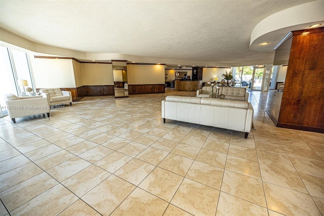 2841 N Ocean Blvd Unit 1801, Fort Lauderdale, FL 33308 - living room with a wainscoted wall, light tile patterned floors, and a textured ceiling