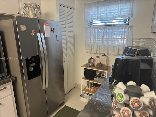 20810 NE 8th Ct Unit 201-18, Miami, FL 33179 - kitchen with stainless steel fridge with ice dispenser, tile patterned floors, white cabinetry, and dark stone countertops
