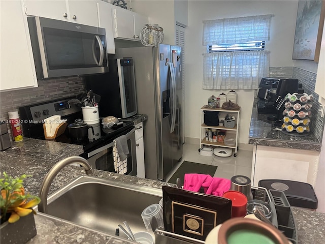 20810 NE 8th Ct Unit 201-18, Miami, FL 33179 - kitchen featuring appliances with stainless steel finishes, decorative backsplash, white cabinetry, and dark countertops