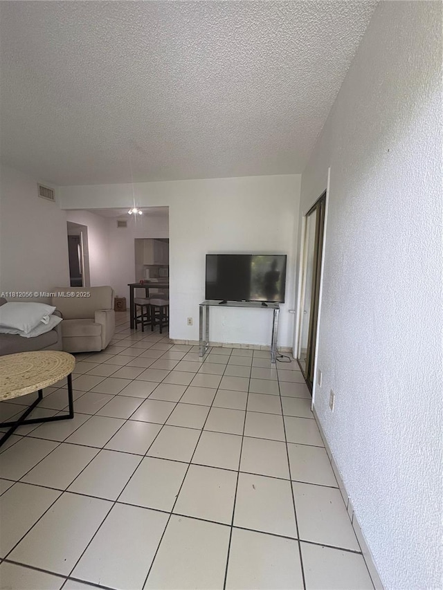 1239 Marseille Dr Unit 7, Miami Beach, FL 33141 - living room featuring a textured ceiling, a textured wall, and light tile patterned floors