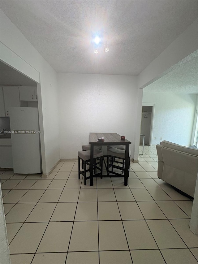 1239 Marseille Dr Unit 7, Miami Beach, FL 33141 - dining room featuring a textured ceiling and light tile patterned floors