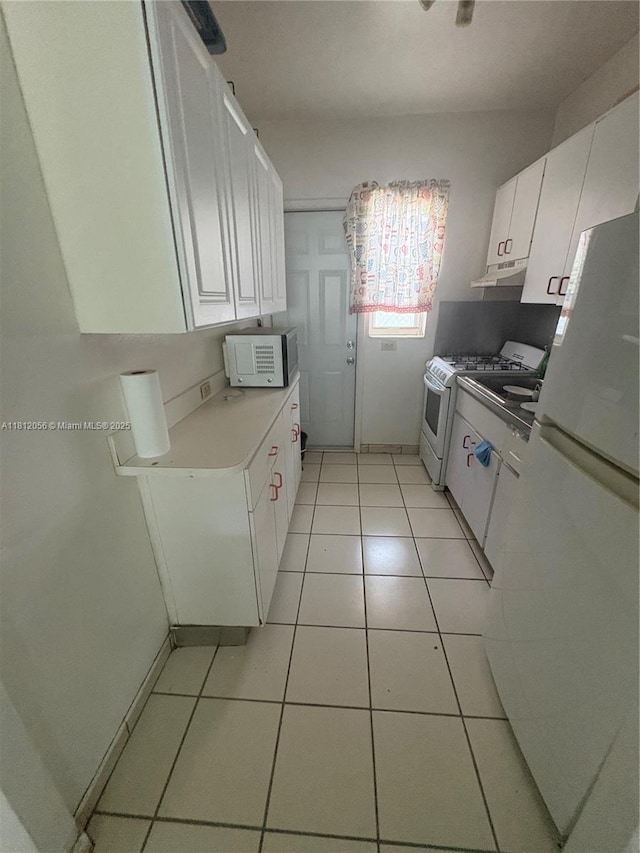 1239 Marseille Dr Unit 7, Miami Beach, FL 33141 - kitchen featuring white appliances, under cabinet range hood, white cabinets, and light tile patterned floors