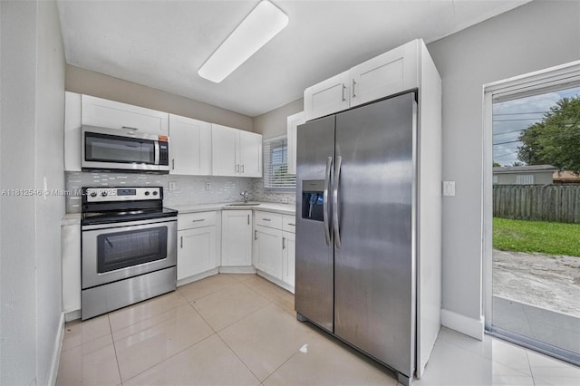 610 Snowden Dr, Lake Worth, FL 33461 - kitchen featuring appliances with stainless steel finishes, white cabinetry, light countertops, tasteful backsplash, and a sink