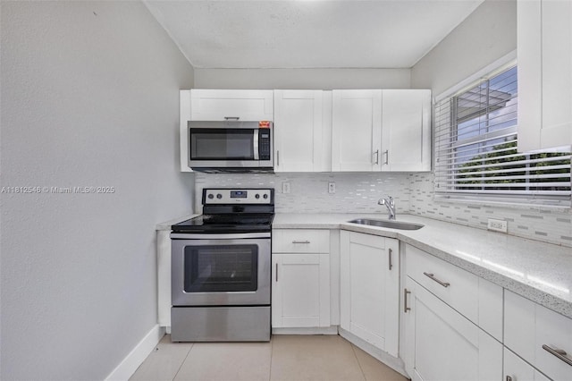 610 Snowden Dr, Lake Worth, FL 33461 - kitchen with appliances with stainless steel finishes, a sink, backsplash, light countertops, and white cabinets