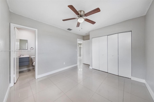 610 Snowden Dr, Lake Worth, FL 33461 - unfurnished bedroom with baseboards, light tile patterned floors, a closet, and ensuite bath