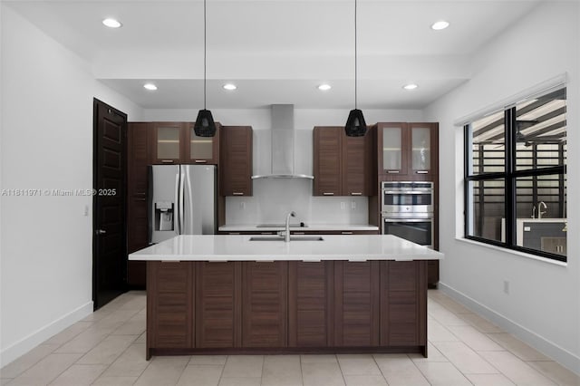 15924 SW 136th Way, Miami, FL 33196 - kitchen featuring wall chimney range hood, appliances with stainless steel finishes, light countertops, an island with sink, and glass insert cabinets