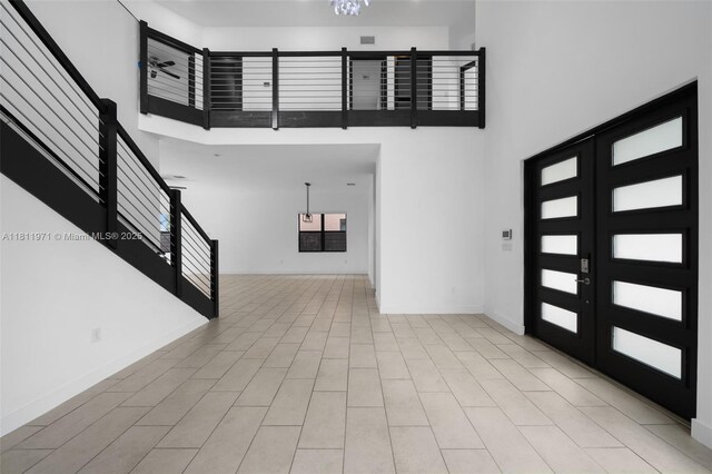 15924 SW 136th Way, Miami, FL 33196 - empty room with stairs, a chandelier, a towering ceiling, and french doors