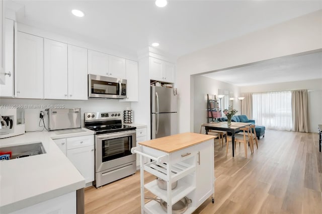 733 NW 30th Ct Unit 2, Wilton Manors, FL 33311 - kitchen with appliances with stainless steel finishes, light wood-style flooring, white cabinets, recessed lighting, and a sink