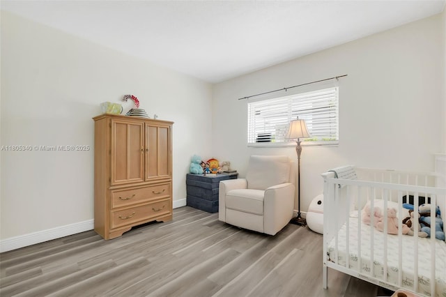 733 NW 30th Ct Unit 2, Wilton Manors, FL 33311 - bedroom featuring light wood-type flooring, a nursery area, and baseboards