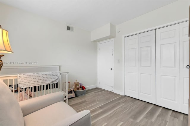 733 NW 30th Ct Unit 2, Wilton Manors, FL 33311 - bedroom featuring wood finished floors, a closet, and a nursery area