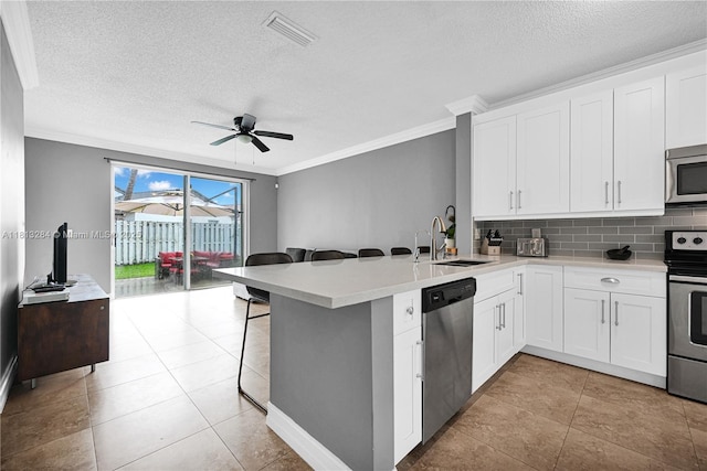 17473 SW 22nd St, Miramar, FL 33029 - kitchen featuring stainless steel appliances, a sink, ornamental molding, a textured ceiling, and a peninsula