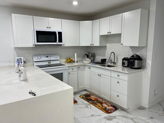 2905 Pierce St Unit 7, Hollywood, FL 33020 - kitchen featuring white appliances, a sink, light marble finish floors, white cabinets, and light countertops