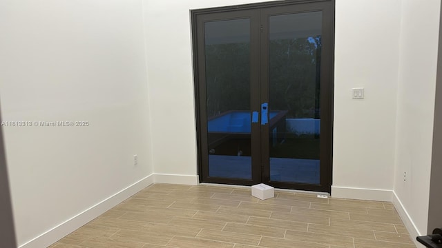 14074 Whittier Prt, Charlotte, FL 33981 - empty room with baseboards, light wood-style floors, and french doors