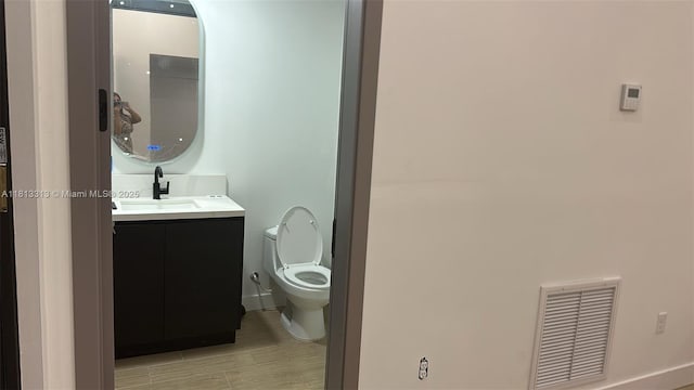 14074 Whittier Prt, Charlotte, FL 33981 - bathroom featuring vanity, toilet, and wood finished floors