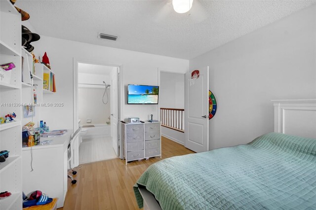 9280 Boca Gardens Pkwy Unit B, Boca Raton, FL 33496 - bedroom with light wood-type flooring, a textured ceiling, and ensuite bath