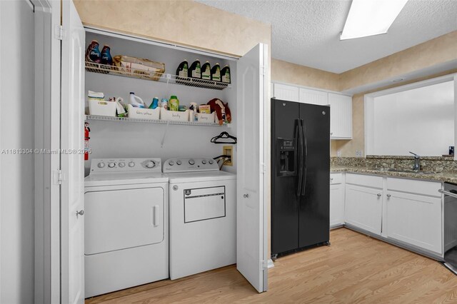 9280 Boca Gardens Pkwy Unit B, Boca Raton, FL 33496 - washroom featuring washing machine and dryer, light wood finished floors, and a textured ceiling
