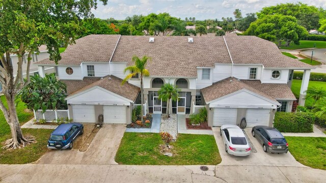 9280 Boca Gardens Pkwy Unit B, Boca Raton, FL 33496 - townhome / multi-family property featuring concrete driveway, a shingled roof, an attached garage, and a front yard