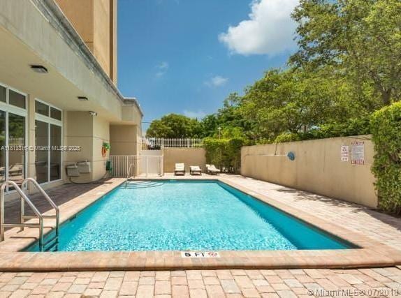 2425 SW 27th Ave Unit 705, Miami, FL 33145 - community pool with a fenced backyard and a patio