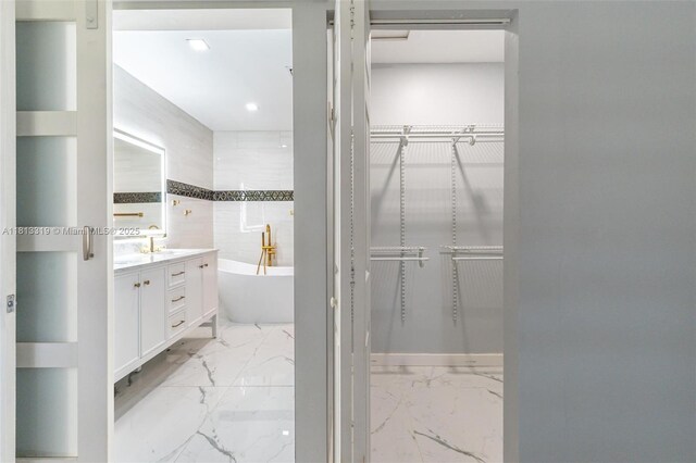 9234 Wedgewood Ln Unit D7, Tamarac, FL 33321 - full bath with a freestanding bath, vanity, a walk in closet, marble finish floors, and recessed lighting